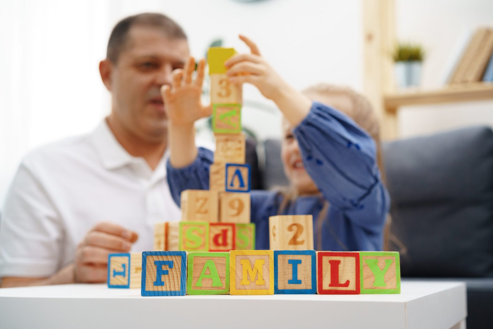 Grandfather and granddaughter playing wooden cubes in living room